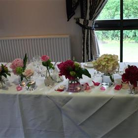 fwthumbFull length top table display of hotchpotch vases and fresh petals.jpg